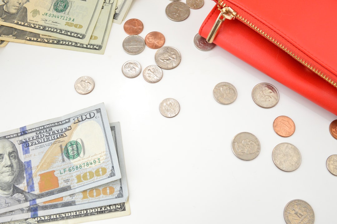 Red wallet with scattered coins and dollar bills, symbolizing earnings growth through affiliate marketing strategies.
